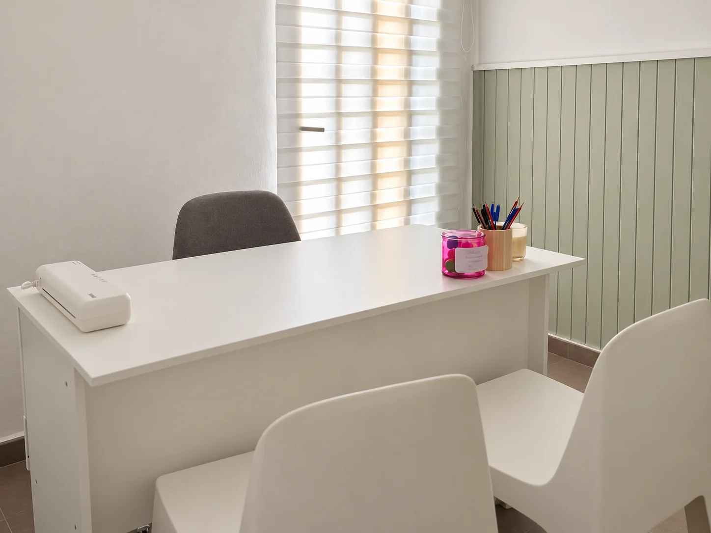 Sala de consulta de CRECE en Xàtiva, con escritorio blanco, sillas y pared en verde suave