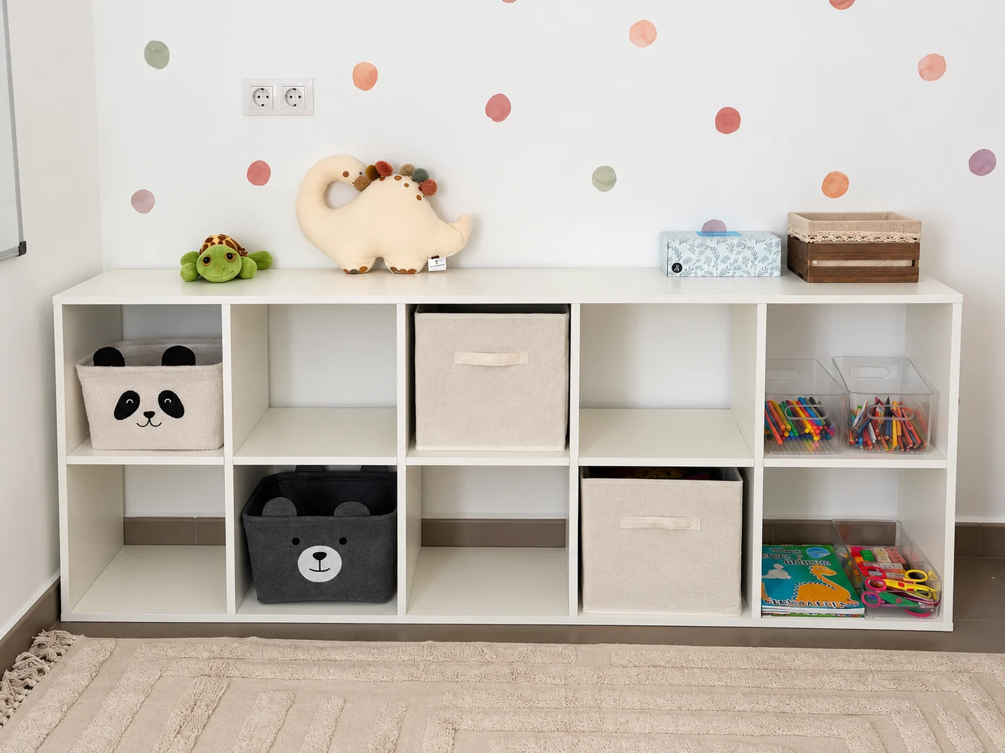 Sala infantil real de CRECE en Xàtiva, con materiales educativos y pared de lunares de colores suaves