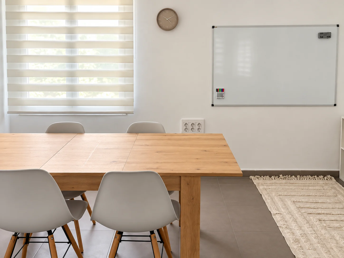 Sala de trabajo en grupo y talleres de CRECE en Xàtiva, con mesa, sillas y pizarra